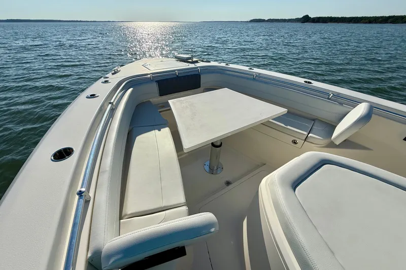 Slide: The Image of 2023 Cobia 350 Center Console boat interior with seating and table on open water. - 25
