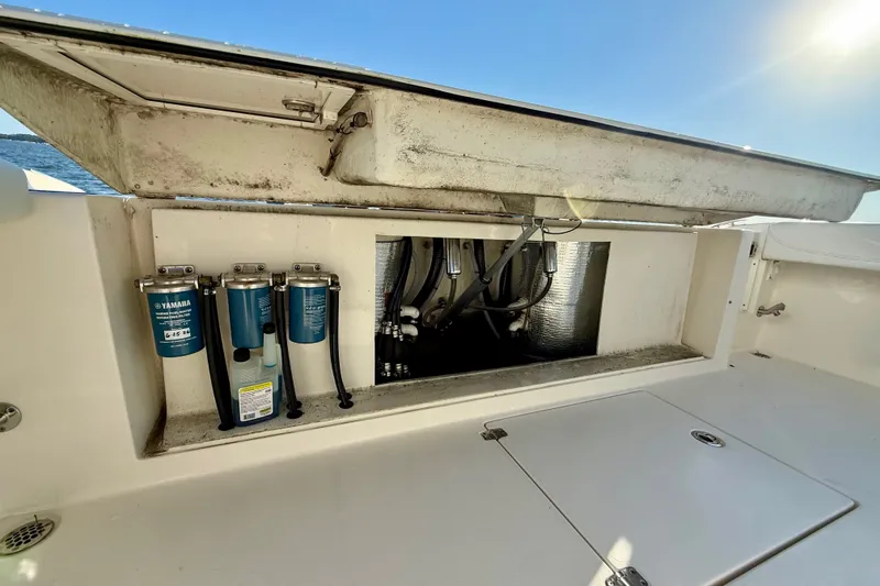 Slide: The Image of 2023 Cobia 350 Center Console boat compartment with Yamaha filters and hoses. - 18