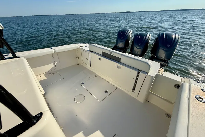 Slide: The Image of 2023 Cobia 350 Center Console boat with triple engines on open water. - 14