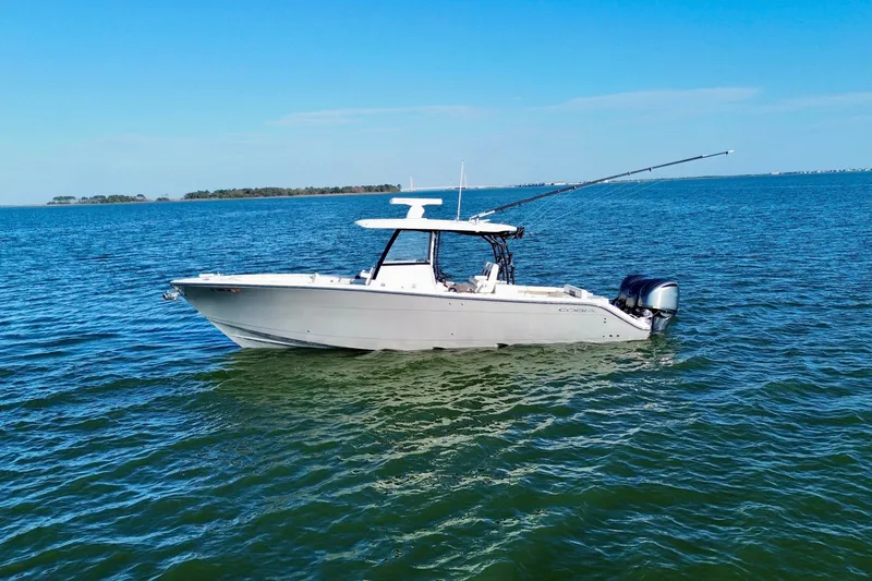 The Image of 2023 Cobia 350 Center Console boat on calm blue water under clear sky. - 0