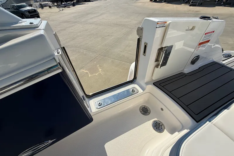 Slide: The Image of 2021 Chaparral 280 OSX boat deck with open door, showcasing sleek design and drainage features. - 30