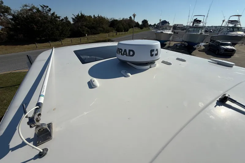 Slide: The Image of 2021 Chaparral 280 OSX boat with radar equipment on deck, docked near other boats. - 27