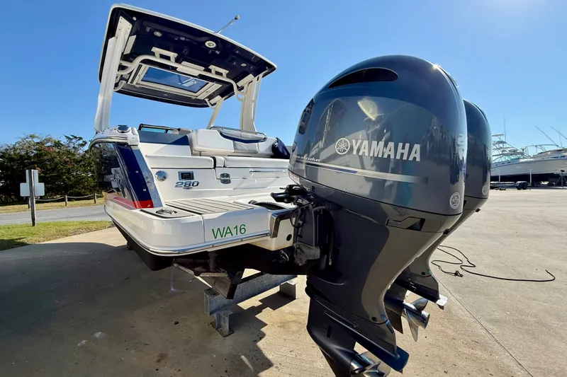 Slide: The Image of 2021 Chaparral 280 OSX boat with Yamaha outboard engines, parked outdoors on a sunny day. - 33