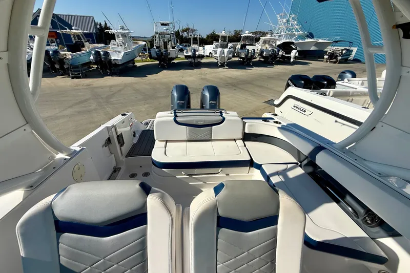 Slide: The Image of Interior view of a 2021 Chaparral 280 OSX boat with seating and docked vessels. - 26