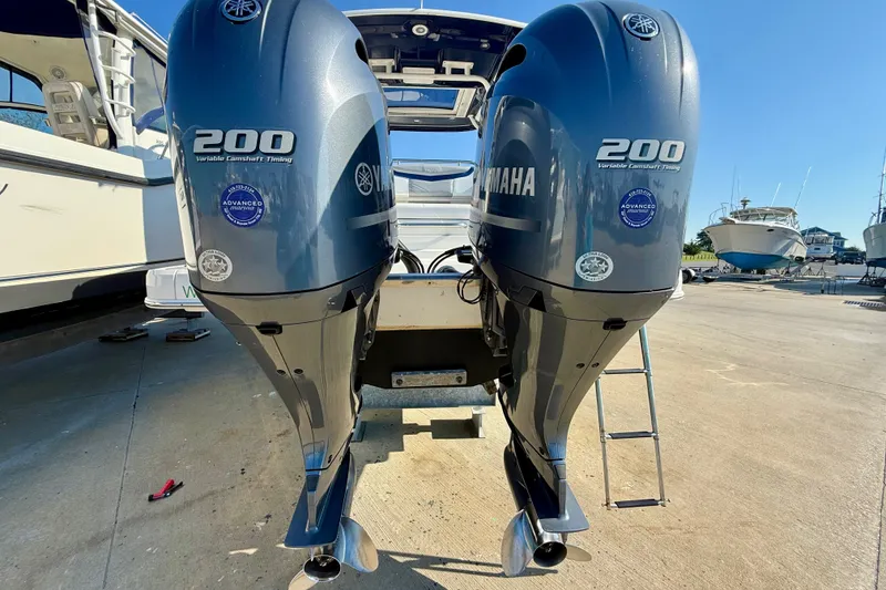 Slide: The Image of Twin Yamaha 200 engines on a 2021 Chaparral 280 OSX boat, docked outdoors. - 32
