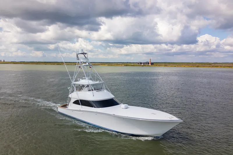 Slide: The Image of 2014 Viking 70C yacht cruising on a calm waterway under cloudy skies. - 4