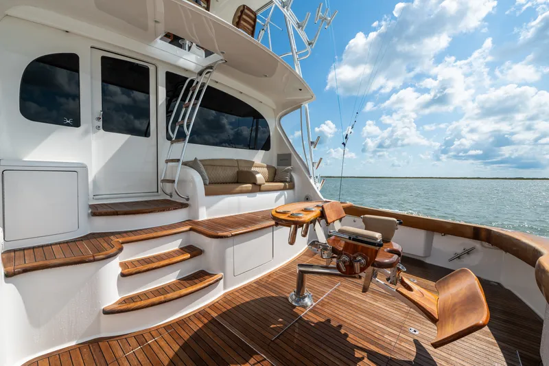 Slide: The Image of Luxurious 2014 Viking 70C yacht deck with wooden flooring and fishing chair, under a bright sky. - 15