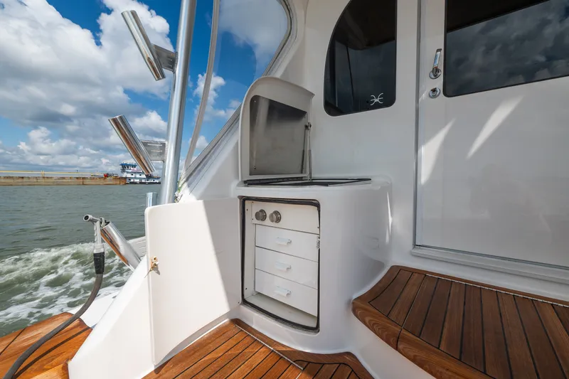 Slide: The Image of 2014 Viking 70C yacht deck with wooden flooring and built-in storage. - 25