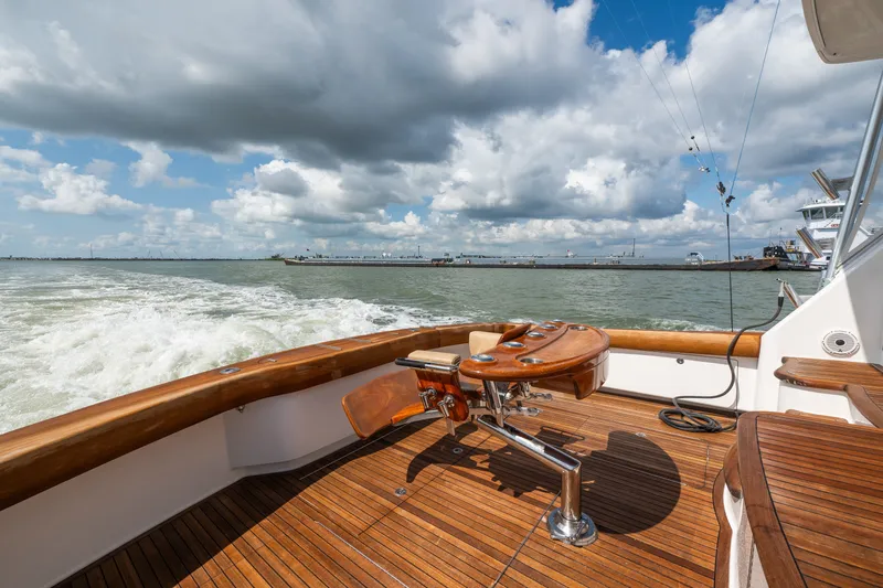 Slide: The Image of Luxurious 2014 Viking 70C yacht deck with wooden flooring, cruising under a cloudy sky. - 21