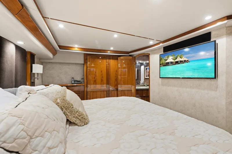 Slide: The Image of Luxurious bedroom interior of 2014 Viking 70C yacht with elegant wood finishes and wall-mounted TV. - 55