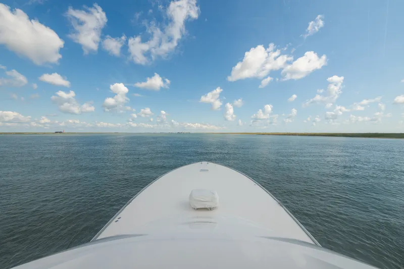 Slide: The Image of Bow of 2014 Viking 70C yacht cruising under a clear blue sky. - 35