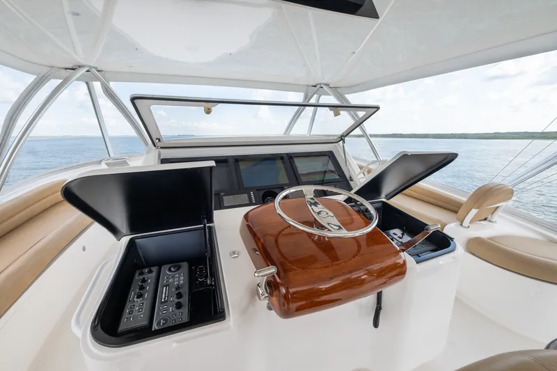 Slide: The Image of Helm of 2014 Viking 70C yacht with polished wood steering wheel and navigation controls. - 69