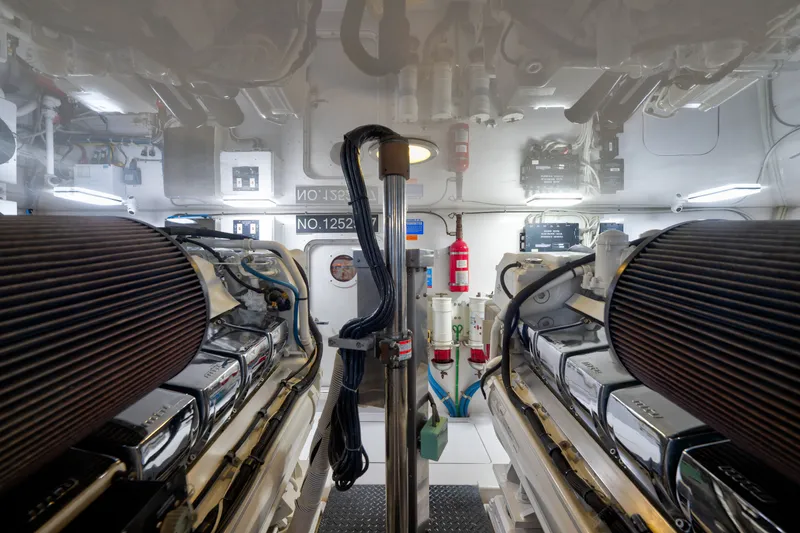 Slide: The Image of Engine room of a 2014 Viking 70C yacht, featuring dual engines and safety equipment. - 75