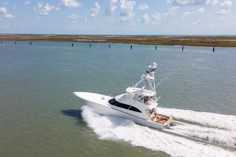 Slide: The Image of 2014 Viking 70C yacht cruising on open water under a partly cloudy sky. - 13