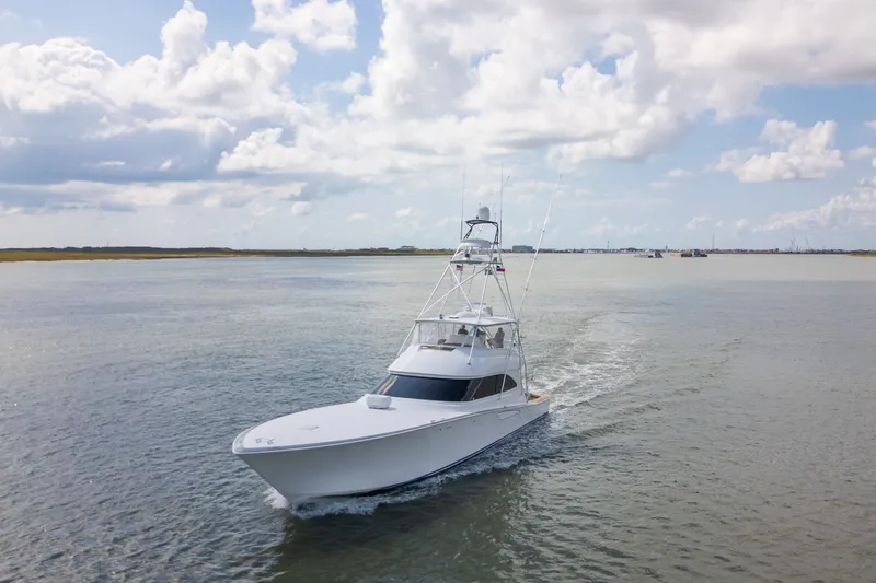 Slide: The Image of 2014 Viking 70C yacht cruising on open water under a partly cloudy sky. - 5