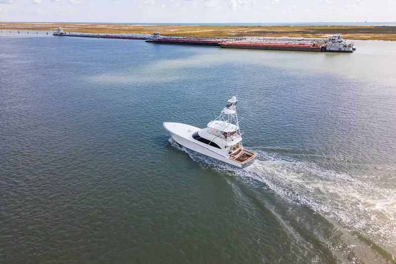 Slide: The Image of Aerial view of 2014 Viking 70C yacht cruising in open water near a dock. - 9