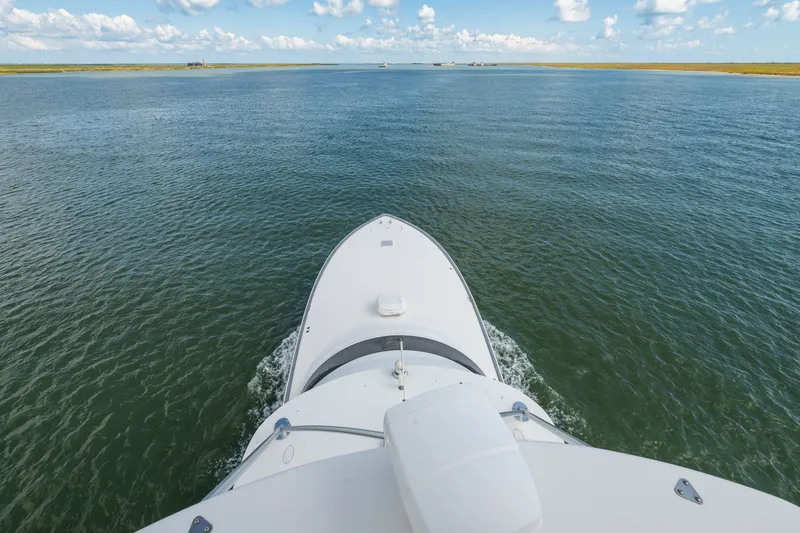 Slide: The Image of Bow view of 2014 Viking 70C yacht cruising on open water under blue sky. - 40