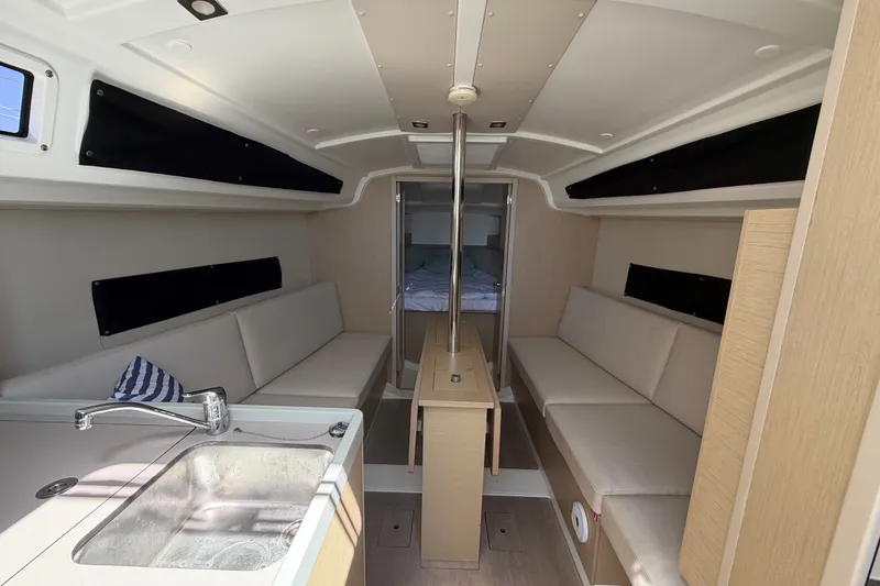 Slide: The Image of Interior of 2021 Beneteau Oceanis 30.1 sailboat, featuring modern seating and compact kitchen area. - 3