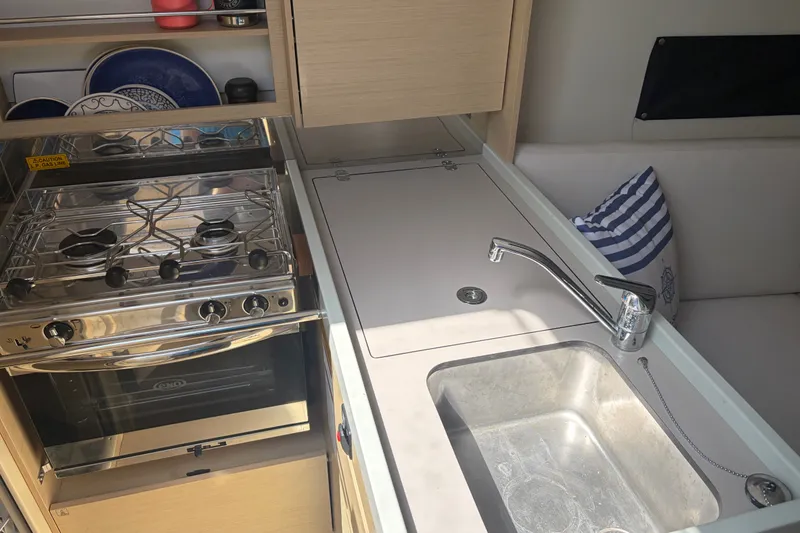 Slide: The Image of Compact kitchen area in a 2021 Beneteau Oceanis 30.1 yacht, featuring stove and sink. - 10