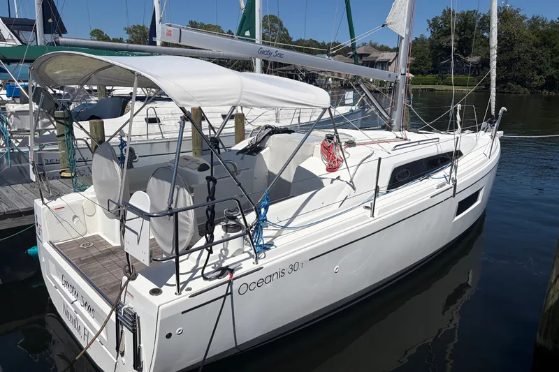 Slide: The Image of 2021 Beneteau Oceanis 30.1 sailboat docked in a marina, featuring a sleek design. - 1
