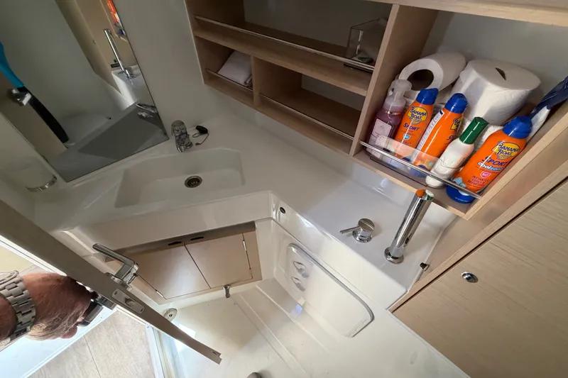 Slide: The Image of Compact bathroom in 2021 Beneteau Oceanis 30.1 yacht with sink, storage, and toiletries. - 14