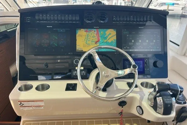 Slide: The Image of Helm of 2019 Boston Whaler 380 Realm with advanced navigation displays and controls. - 19