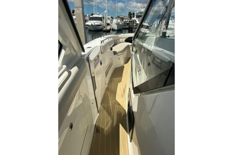 Slide: The Image of 2019 Boston Whaler 380 Realm boat deck with sleek design and marina view. - 10