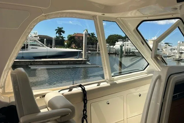 Slide: The Image of Interior view of 2019 Boston Whaler 380 Realm, overlooking marina with boats and palm trees. - 25
