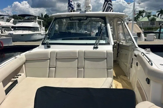 Slide: The Image of 2019 Boston Whaler 380 Realm boat interior with seating, docked at marina. - 13