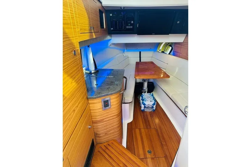 Slide: The Image of 2019 Boston Whaler 380 Realm cabin interior with wood accents and seating area. - 33