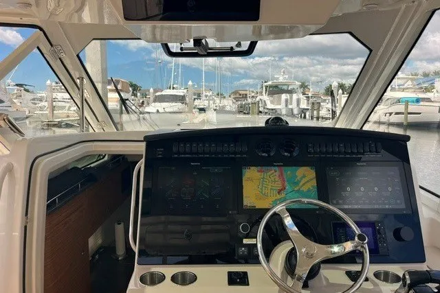 Slide: The Image of Cockpit view of 2019 Boston Whaler 380 Realm with advanced navigation system at marina. - 20
