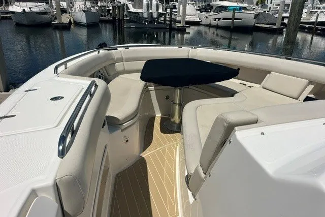 Slide: The Image of 2019 Boston Whaler 380 Realm boat interior with seating and table at marina. - 11