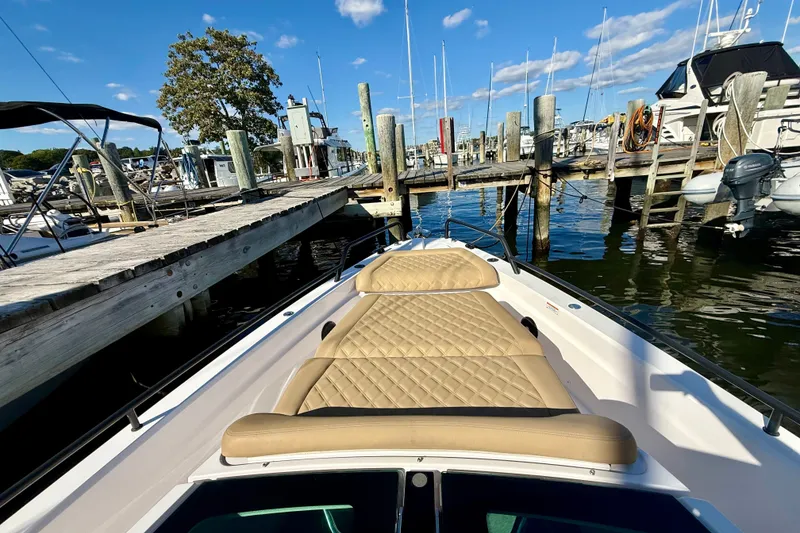 Slide: The Image of Axopar 37 XC Cross Cabin 2021 docked, featuring tan quilted seating, sunny marina view. - 10