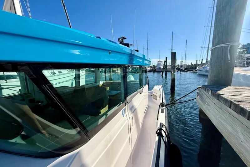 Slide: The Image of 2021 Axopar 37 XC Cross Cabin docked at marina, blue cabin roof, sunny day. - 13