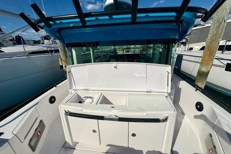 Slide: The Image of 2021 Axopar 37 XC Cross Cabin boat with open storage compartment at dock. - 15