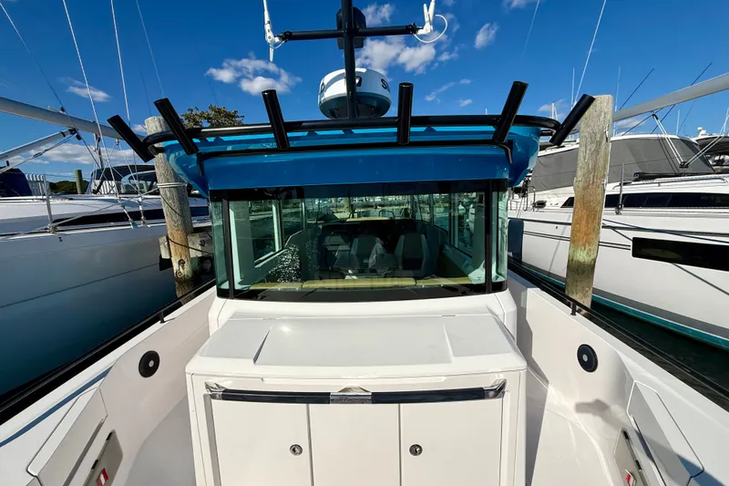 Slide: The Image of 2021 Axopar 37 XC Cross Cabin boat docked, showcasing sleek design and spacious cabin. - 16