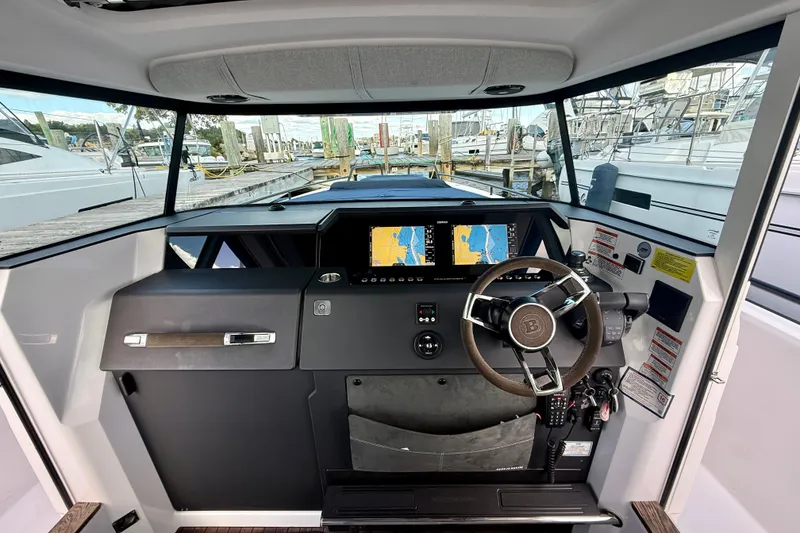 Slide: The Image of 2021 Axopar 37 XC Cross Cabin helm with dual navigation screens and modern steering wheel. - 29