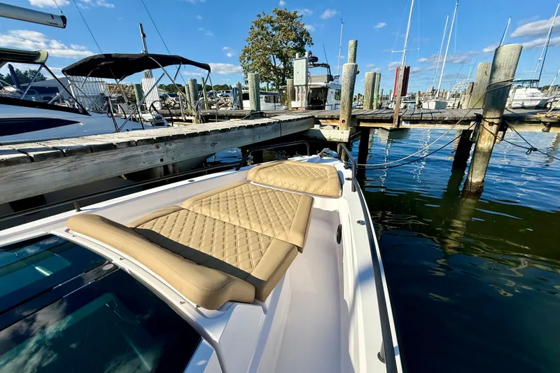 Slide: The Image of 2021 Axopar 37 XC Cross Cabin docked, featuring tan quilted seating and marina backdrop. - 9