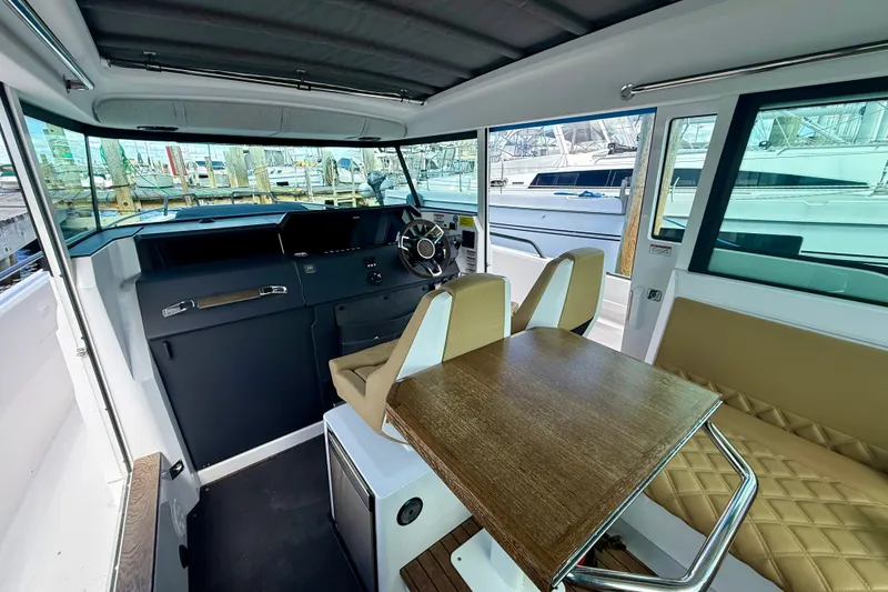 Slide: The Image of Interior of 2021 Axopar 37 XC Cross Cabin with helm, seating, and table. - 27