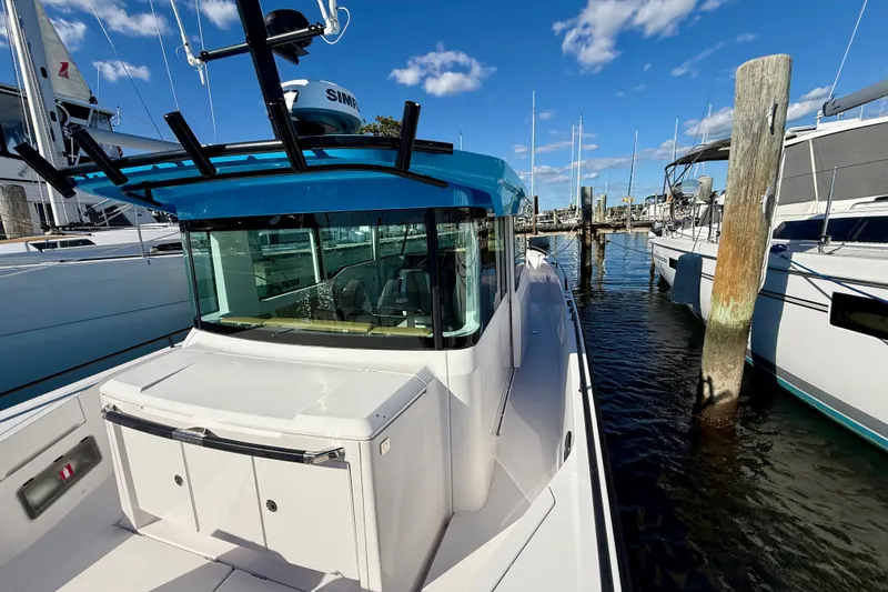 Slide: The Image of 2021 Axopar 37 XC Cross Cabin docked at marina under blue sky. - 17