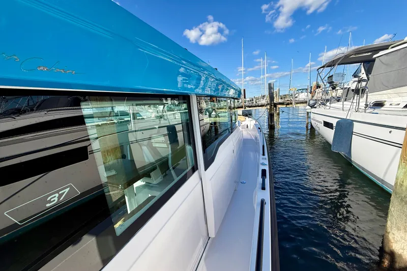 Slide: The Image of 2021 Axopar 37 XC Cross Cabin docked at marina under blue sky. - 20