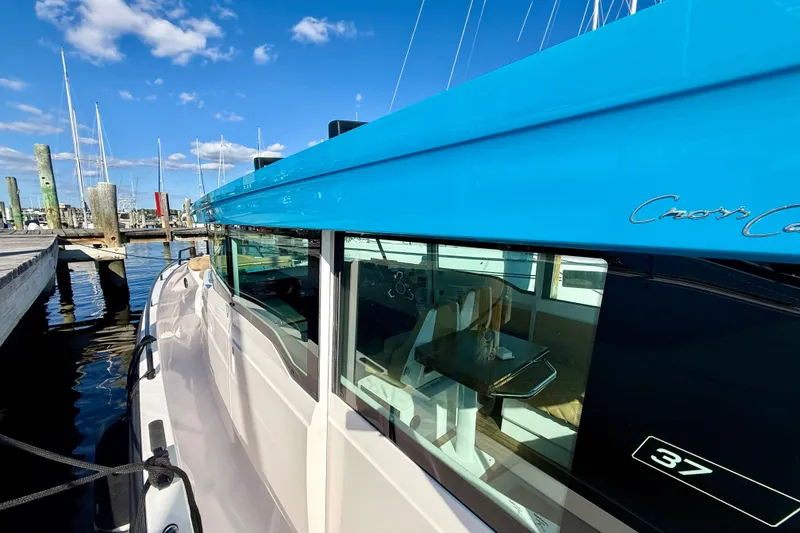 Slide: The Image of 2021 Axopar 37 XC Cross Cabin docked, showcasing sleek design and vibrant blue accents. - 19