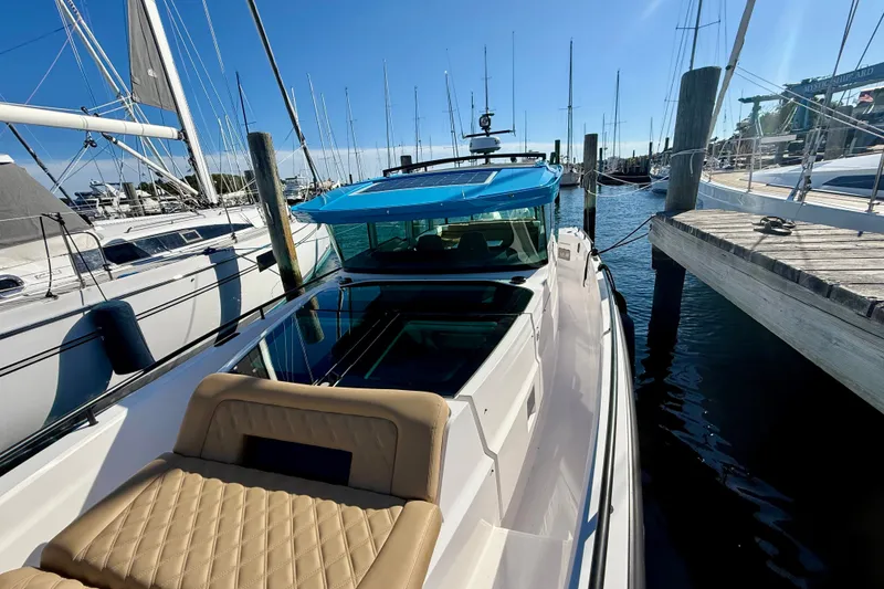 Slide: The Image of 2021 Axopar 37 XC Cross Cabin docked at marina, featuring sleek design and blue roof. - 6