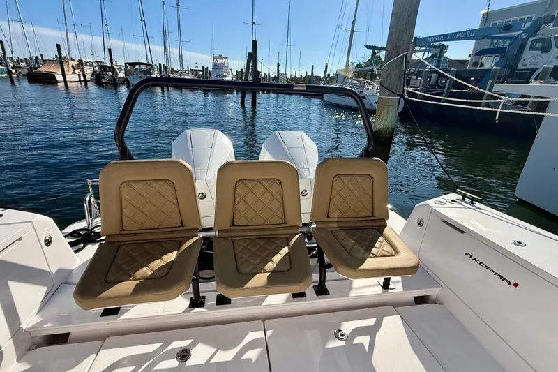 Slide: The Image of 2021 Axopar 37 XC Cross Cabin boat with tan seats at a marina. - 23