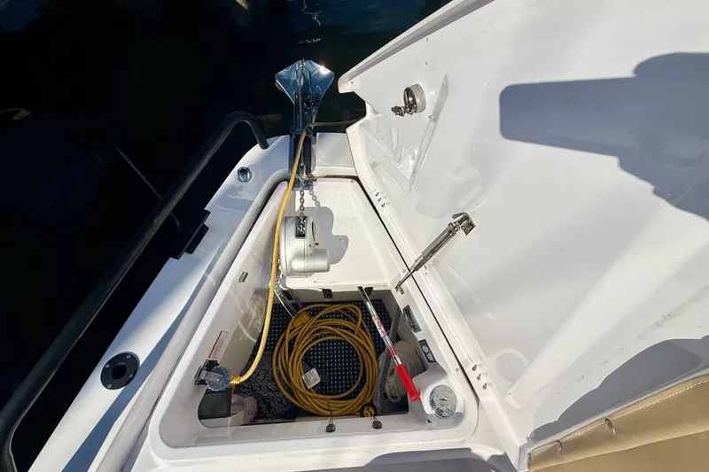 Slide: The Image of Open storage compartment on 2021 Axopar 37 XC Cross Cabin boat, showing equipment and cables. - 11