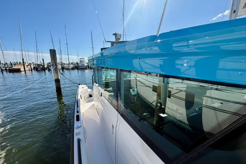 Slide: The Image of 2021 Axopar 37 XC Cross Cabin docked at marina under clear blue sky. - 14