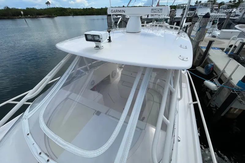 Slide: The Image of 2001 Intrepid 377 Walkaround boat docked, featuring Garmin radar and clear canopy. - 21