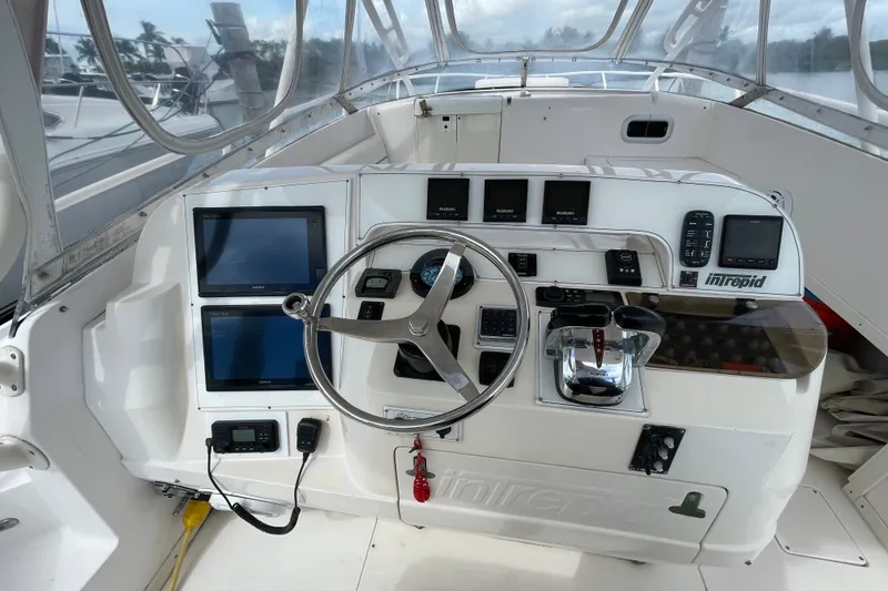 Slide: The Image of 2001 Intrepid 377 Walkaround boat cockpit with steering wheel and navigation controls. - 46