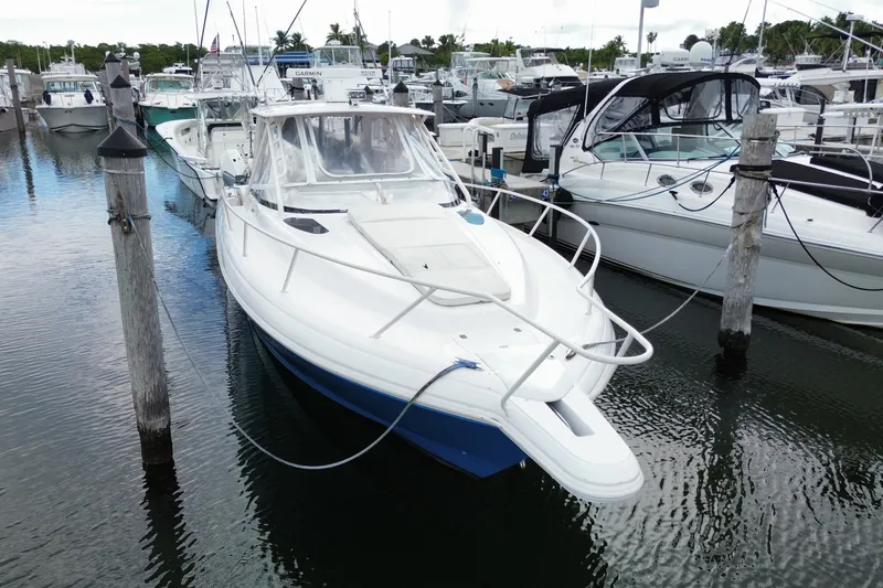 Slide: The Image of 2001 Intrepid 377 Walkaround boat docked in a marina, surrounded by other vessels. - 10