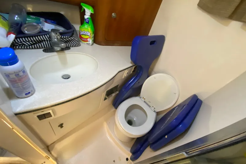 Slide: The Image of 2001 Intrepid 377 Walkaround boat bathroom with sink, toilet, and cleaning supplies. - 40